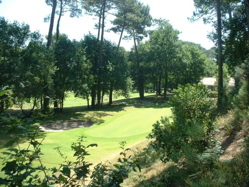 Terrain de golf verdoyant de l'hôtel Côte Et Dune à Biscarrosse Plage, bordé de grands pins et de pelouses impeccables