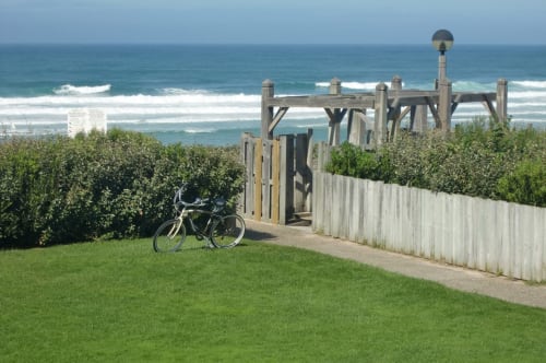 Vélo sur pelouse verte près de la passerelle en bois de l'hôtel Côte et Dune à Biscarrosse, vue océan