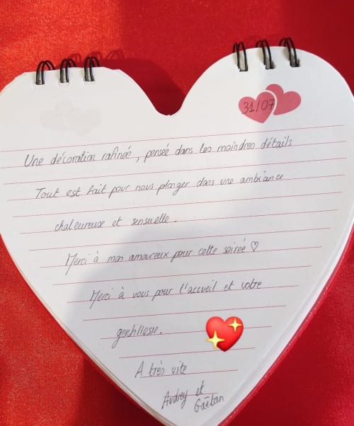 Note de Saint-Valentin en forme de cœur avec message manuscrit en français sur fond rouge à L'Insolite Spa Privatif Toulouse