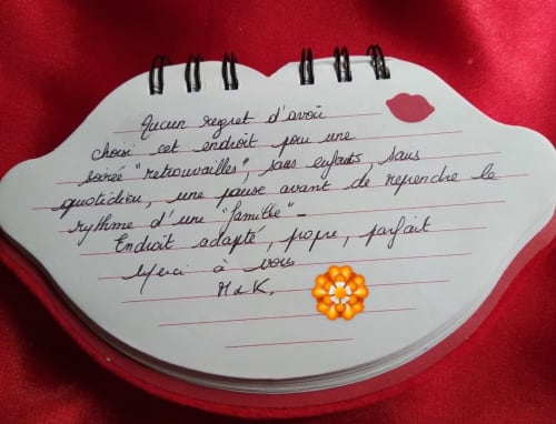 Carnet en forme de cœur avec note manuscrite en français sur tissu rouge au L'Insolite Spa Privatif Toulouse