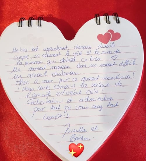 Page de livre d'or en forme de cœur avec message manuscrit en français et deux cœurs roses, L'Insolite Spa Toulouse