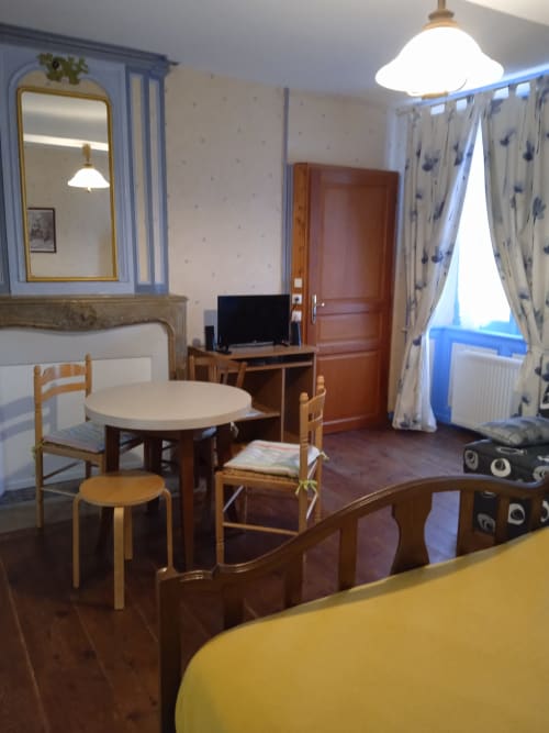 Chambre double confortable à l'hôtel Les Clématites en Cotentin à Saint-Floxel avec table à manger, TV et décor aux touches bleues