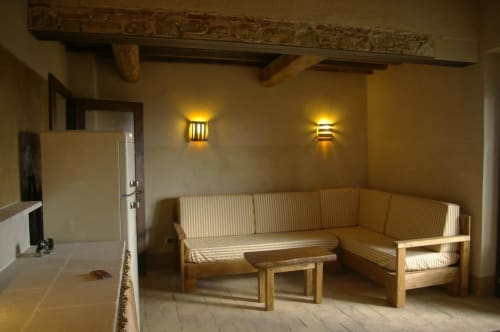 Rustico soggiorno a Casale di Poggioferro con travi in legno, divano rigato e illuminazione calda