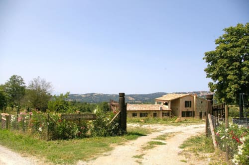 Casale di Poggioferro, B&B rurale con casa colonica in terracotta, vialetto in terra battuta, giardini lussureggianti e dolci colline toscane