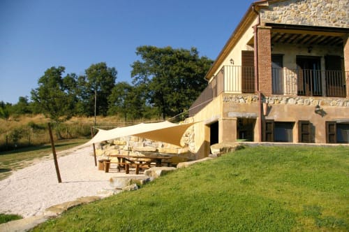 Casale di Poggioferro B&B: edificio in pietra, terrazza, vela ombreggiante e giardini curati in Toscana