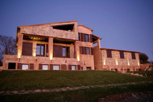 Casale di Poggioferro, un rustico agriturismo color terracotta in Toscana illuminato al tramonto con dettagli in pietra