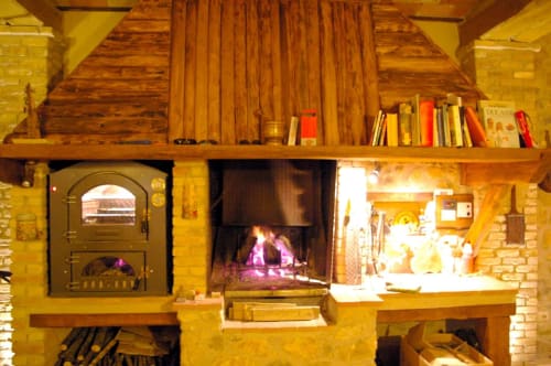 Accogliente camino e stufa a legna in sala in pietra rustica presso Casale di Poggioferro B&B, Toscana