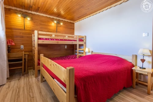 Chambre cosy du Chalet La Louvière avec lit queen-size, lits superposés et décoration de montagne à Fontcouverte-La