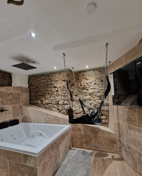 Découvrez la Love Room 3, une suite romantique idéale pour une escapade en couple. Avec ses magnifiques murs en pierre apparents, cette chambre offre une ambiance chaleureuse et authentique. Profitez d'une double vasque moderne et d'un grand écran TV avec Netflix pour vos soirées détente. Le clou du séjour ? Une superbe baignoire à balnéothérapie pour deux, parfaite pour un moment de relaxation absolue. Réservez la Love Room 3 et vivez une expérience inoubliable avec sa superbe balançoire érotique !