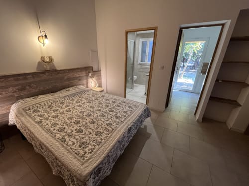 Chambre de mini-villa au Le Maquis Plage avec lit queen-size, salle de bain privée et accès à la terrasse à Poggio-Mezzana
