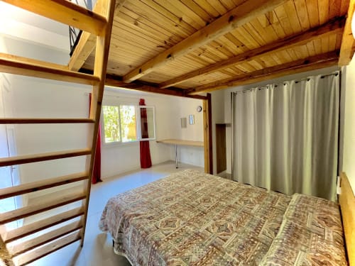 Chambre spacieuse de villa-mini au Maquis Plage avec plafond à poutres en bois, lit, mezzanine et équipements modernes