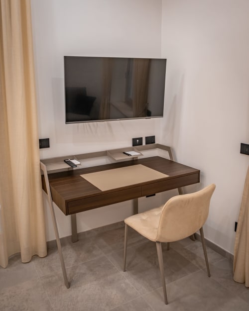 Modern home office workspace at Museo19 apartment in Naples with wall-mounted TV and dark wood desk