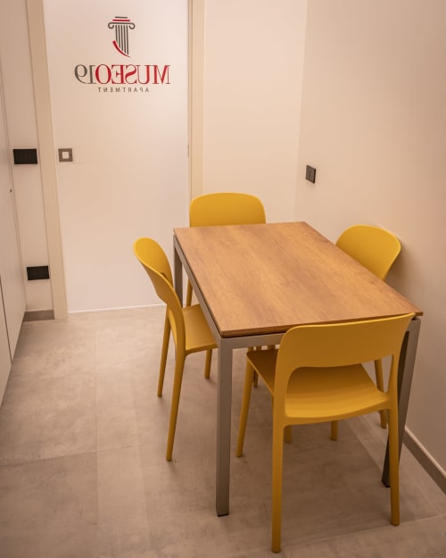 Museo19 apartment meeting room with wooden table and yellow chairs, Naples