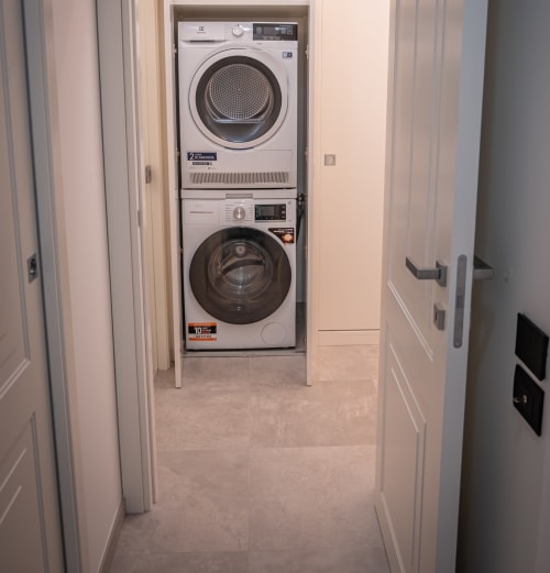 Laundry room with stacked dryer and washing machine at Museo19 apartment in Naples