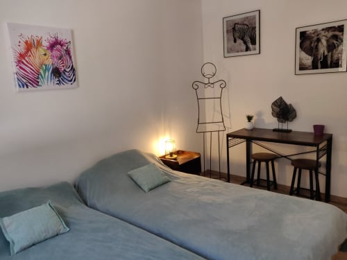 Chambre moderne de l'hôtel Marjo RI au Lauzet-Ubaye avec lit, bureau, mannequin en fil et art animalier