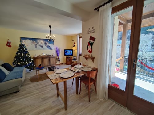 Appartement de vacances Marjo'RI au Lauzet-Ubaye avec table à manger, sapin de Noël et vue montagne depuis le balcon