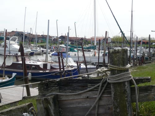 Marina avec bateaux amarrés et poteaux en bois usés à Biscarrosse Plage, près de Côte Et Dune