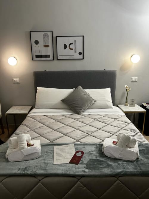 Modern bedroom at AD Trastevere Guest House Rome with gray headboard, white bedding, and ambient lighting