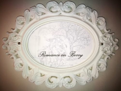 Ornate white oval frame with decorative scrollwork and 'Romance en Berry' text for Aux Prés Du Berry B&B room in Chavin,