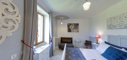 Romance en Berry bedroom at Aux Prés Du Berry, Chavin, featuring blue headboard, white bedding, garden view window, and
