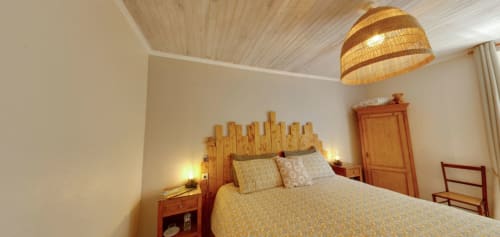 Berry Nature bedroom at Aux Prés Du Berry with wooden headboard, woven pendant lamp, and garden view in Chavin, France