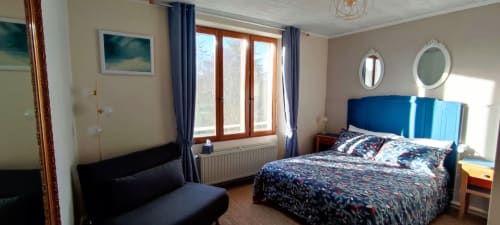 Bright bedroom with blue headboard bed and seating area at Aux Prés Du Berry B&B in Chavin, France