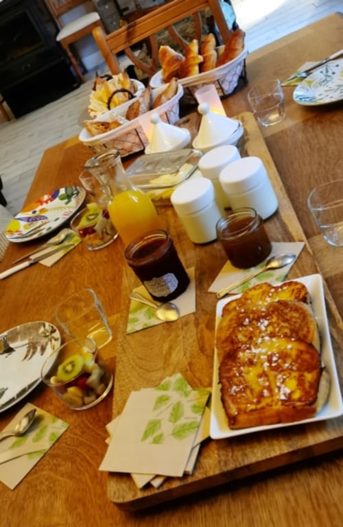 Breakfast table at Aux Prés Du Berry B&B with pastries, jams, juice, and fresh bread in Chavin, France