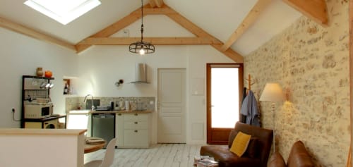 Modern rustic studio at Aux Prés Du Berry with open kitchen, exposed beams, leather seating, and skylight in Chavin, France
