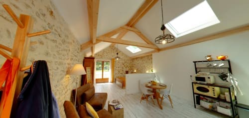 Spacious barn conversion at Aux Prés Du Berry with exposed beams, skylights, stone walls, and modern kitchenette in Chavin,