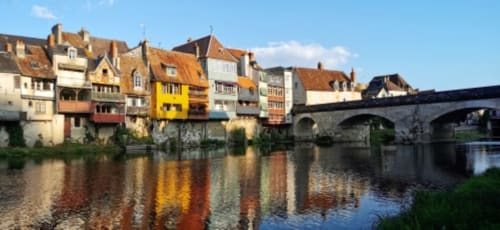 Bâtiments médiévaux colorés reflétés dans la rivière avec pont de pierre aux Prés du Berry, Chavin, France