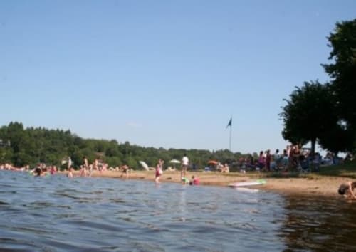 Plage de sable aux Prés du Berry avec baigneurs et familles profitant de l'eau à Chavin, France