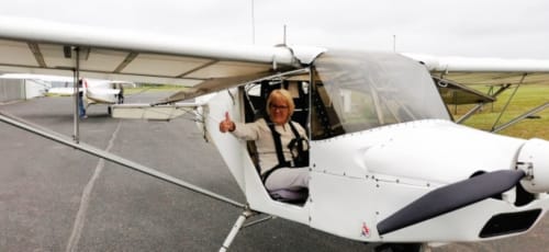 Pilote faisant un pouce levé depuis un petit avion sur le terrain d'aviation près d'Aux Prés Du Berry, Chavin, France