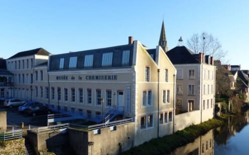 Aux Prés Du Berry, gîte à Chavin, France - bâtiment au bord de l'eau avec façades jaune et blanc et clocher
