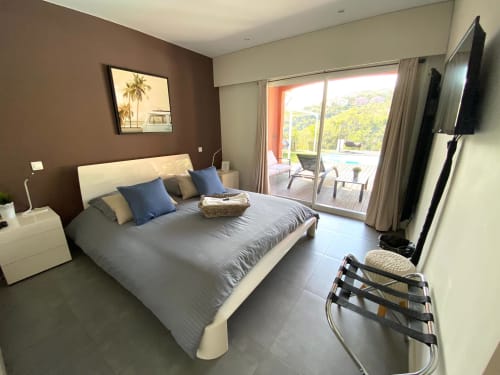 Chambre de luxe à la Villa Colina avec lit queen-size, vue sur terrasse, TV écran plat et équipements modernes à Mandelieu-la-Napoule