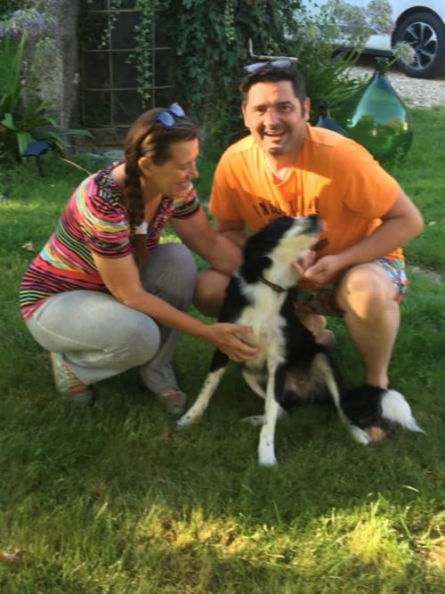 Couple with black and white dog in grassy garden at Aux Prés Du Berry B&B in Chavin, France