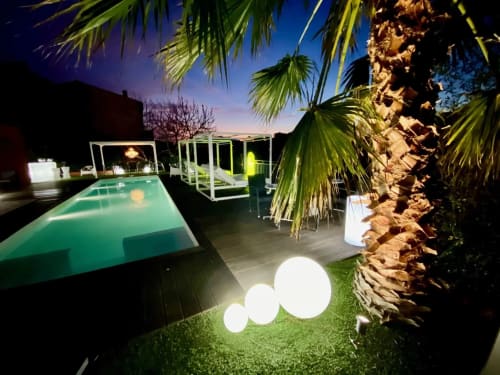 Piscine et jardin de la Villa Colina au crépuscule, Mandelieu la Napoule. Piscine illuminée, palmiers, espaces de détente.