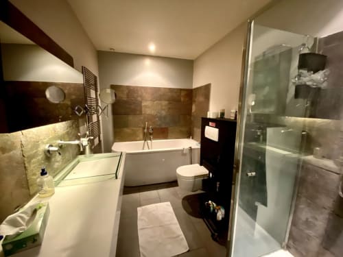 Salle de bain moderne à la Villa Colina BnB à Mandelieu la Napoule avec double vasque, baignoire, douche et sèche-serviettes électrique