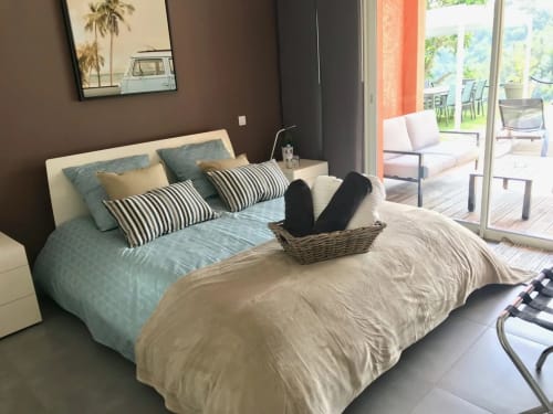 Chambre moderne de la Villa Colina B&B à Mandelieu avec vue sur l'océan, coussins rayés et accès à la terrasse