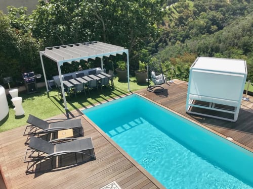 Terrasse de piscine luxe Villa Colina avec chaises longues, pergola et piscine turquoise surplombant les jardins