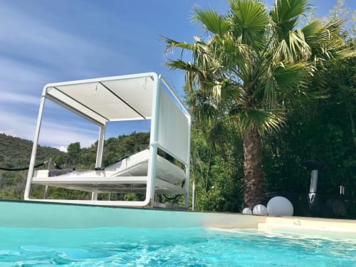 Pergola blanche moderne et transats face à la piscine turquoise de la Villa Colina, Mandelieu-la-Napoule