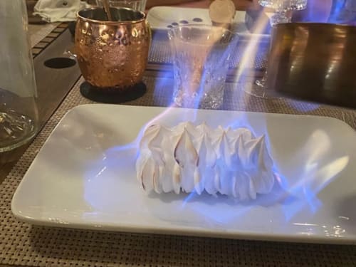 Élégant dessert dressé avec pics de meringue et éclairage bleu au Le Maquis Plage, Poggio-Mezzana