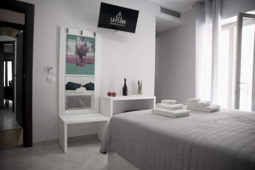 Camera moderna presso B&B La Pigna a Filiano con arredi bianchi, specchiera e asciugamani ordinatamente disposti