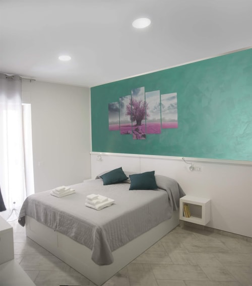 Camera moderna della B&B La Pigna a Filiano con parete azzurra, letto matrimoniale e tela artistica con albero rosa