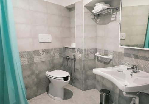 Bagno moderno presso B&B La Pigna a Filiano con doccia walk-in, toilet, lavabo e rivestimenti in piastrelle decorate.