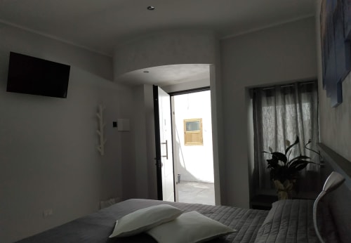 Camera moderna di B&B La Pigna a Filiano con letto, TV e luminosa entrata dal balcone
