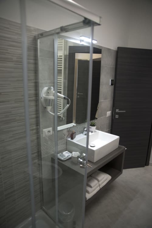 Bagno moderno della B&B La Pigna a Filiano con cabina doccia, lavabo a coppa e rivestimenti in piastrelle scure