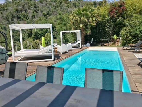 Piscine luxe Villa Colina aux eaux turquoise, terrasse en bois, pergolas blanches et jardin méditerranéen à Mandelieu-la-Napoule