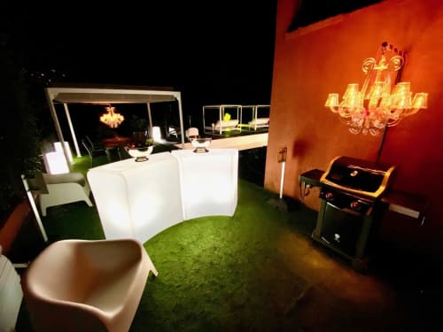 Espace événementiel extérieur Villa Colina illuminé la nuit, avec sièges éclairés, lustre et pelouse verdoyante à Mandelieu la Napoule