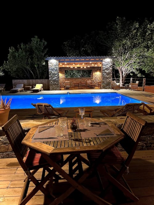 Dîner en bord de piscine illuminé au Le Maquis Plage, Poggio-Mezzana, avec bar pavillon éclairé