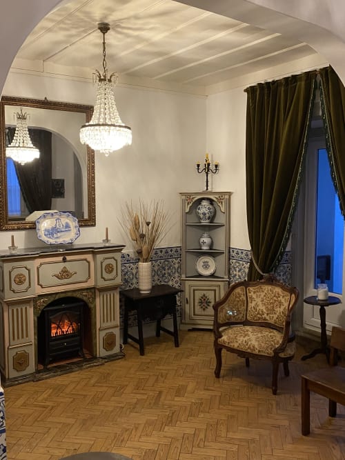 Elegant living room at Patio Da Villa with fireplace, crystal chandelier, period furniture, and blue ceramic décor